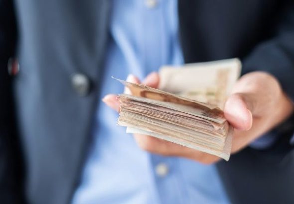 Businessman Hand Holding Thai Baht Banknote Stack_
